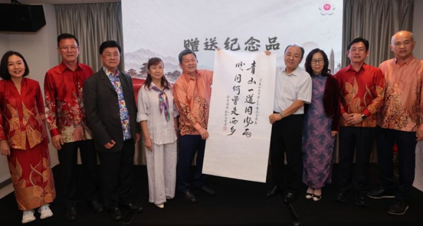 中国驻马大使欧阳玉靖（右4）赠送亲笔挥毫的墨宝赠予华总会长林家全（左5）。