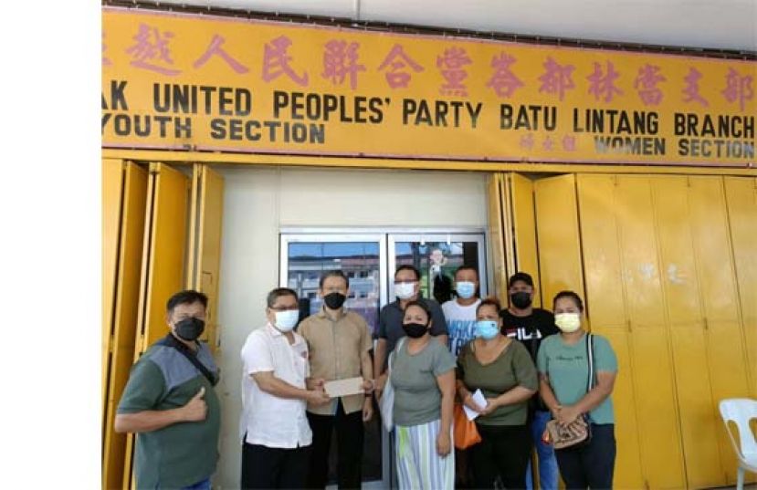 人联党峇都林当支部主席薛华东（左3）及秘书王运才（左4）见证热心者陈明德（左2）捐善款予甘榜达闽达雅灾民。