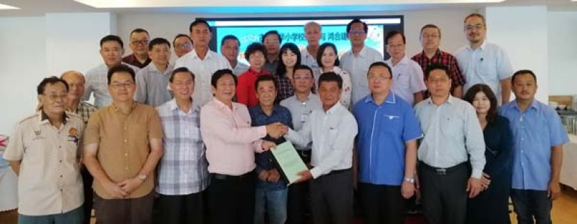 在古晋中华小学校董会执行顾问黄张金发（左五）及拿督黄良杰（左六）的见证下，古晋中华小学校董会主席拿督王长福（左四）与鸿合建筑东主黄亚水（右五）互换二小新教学楼多用途礼堂承建合约，左起为五小副主席甲必丹黄锦就、秘书长田松茂、二小副主席兼扩建工程筹建委员会主席张光福；右起为四小监学吴孟敦、二小校长张丽萍、名誉顾问蔡岷谷及署理主席蔡文铎。