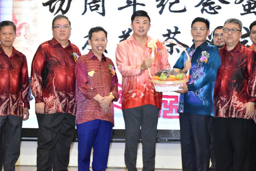 图示：晚宴筹委会主席陈玮政（左四）赠送水果礼篮予中国驻古晋总领事程广中（右二）。