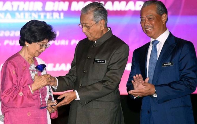 首相敦马哈迪（中）颁发反毒杰出人物特别奖予夫人敦茜蒂哈斯玛(左)，右为内政部长丹斯里慕尤丁。