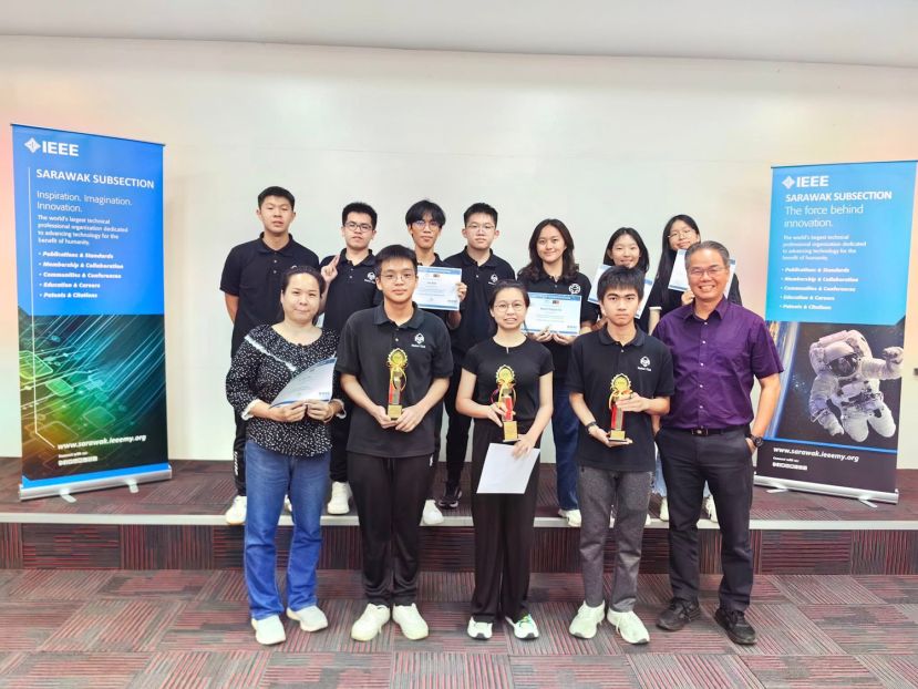 一中校长李志鹏（前排右一）与指导老师沈宛慧（前排左一）携手参赛选手合影，见证团队在本次机器人竞赛中取得的优异成绩。