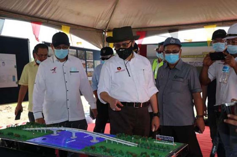 砂首长拿督巴丁宜阿邦佐哈里（中）欣赏查看沙里拔河大桥模型。