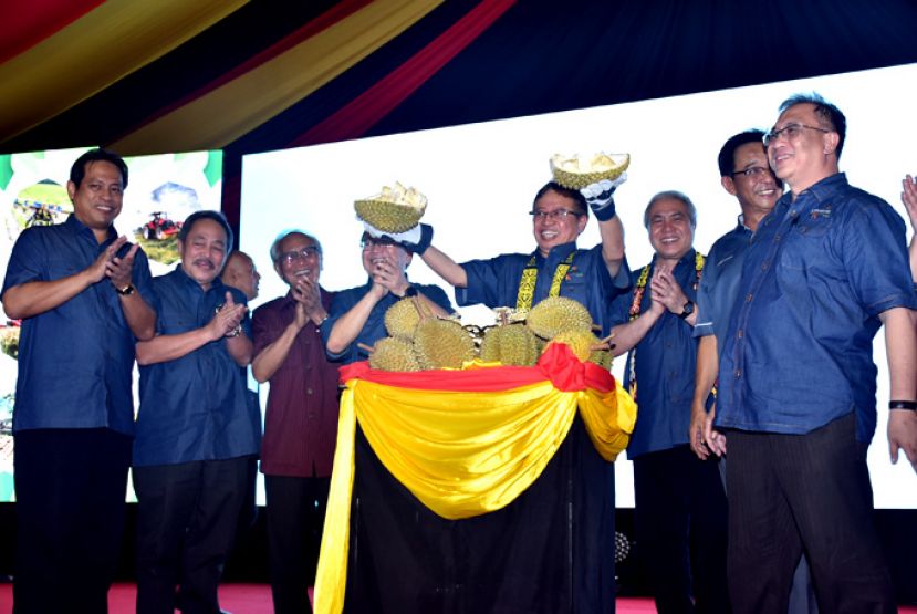 砂首长拿督巴丁宜阿邦佐哈里（中）剥开榴莲，象征2019年砂拉越农业展销会开幕。