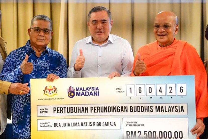 陆兆福(中)移交模拟支票拨款给达摩拉达那(右)，左为团结部长艾伦达干。   