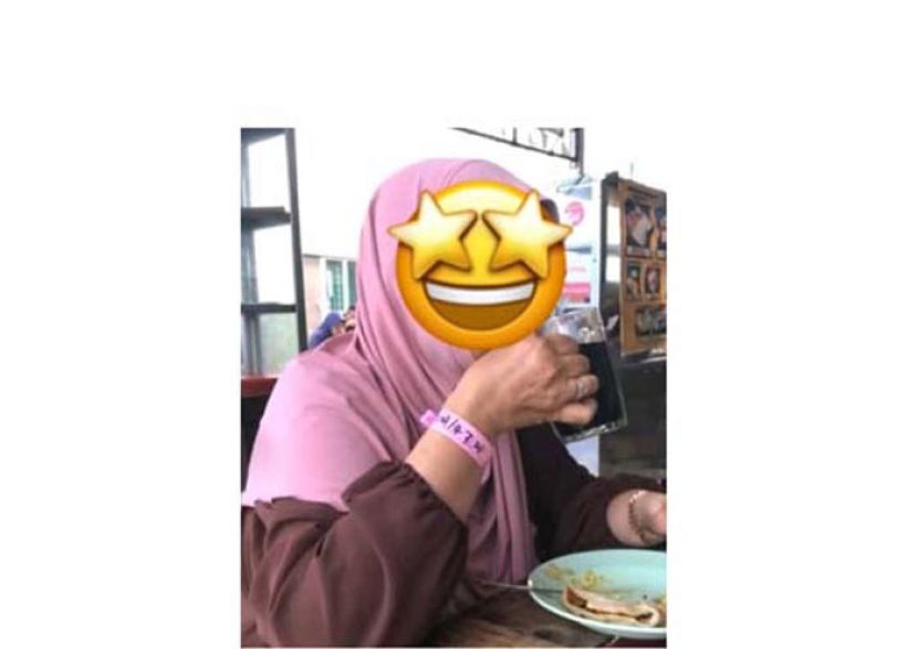 妇女居家隔离时，戴着粉色手环外出用餐。（档案照片）