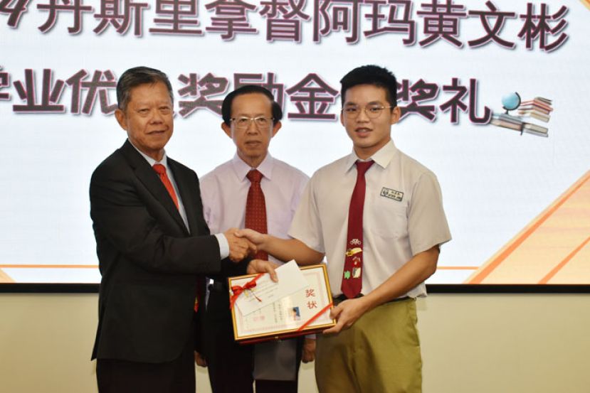 人力资源发展组主任郑佑上（中）陪同会长拿督陈日枝（左）颁发奖励金予获奖同学。