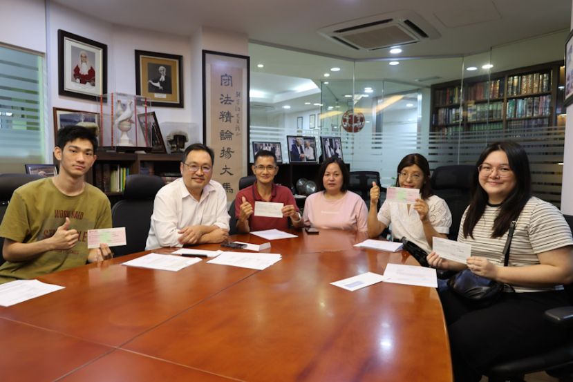实旦宾区国会议员兼浮罗岸州议员张健仁（左2）与领取李氏基金会助学金支票的受惠学子及代领助学金支票的家属合影。