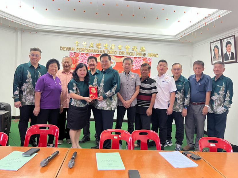 大会上，主席拿督吴标生博士（左6）为表感谢执行秘书谢丽凤的任劳任怨，特别赠送一个红包予后者。
