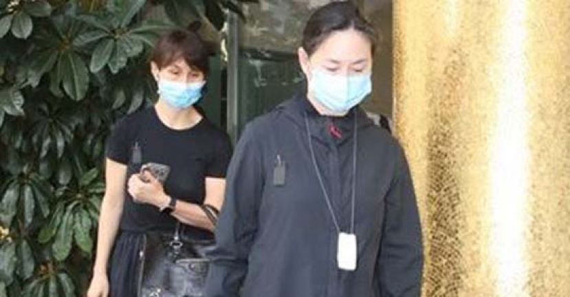 何超琼(前)与妹妹步出殡仪馆。