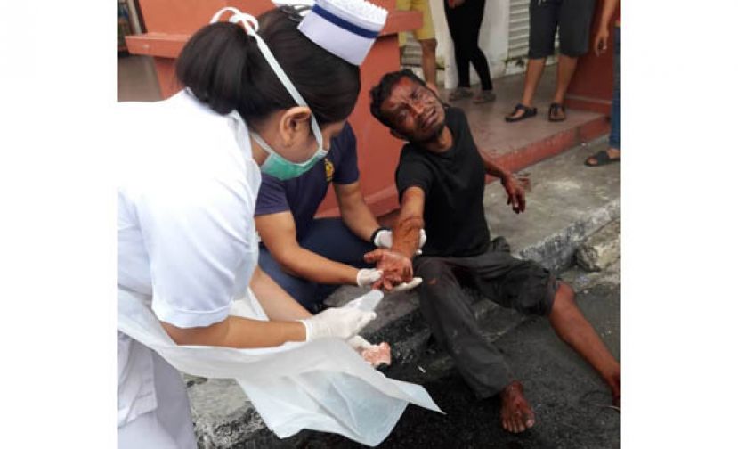 砸车镜造成手部受伤流血的嫌犯接受伤势处理。