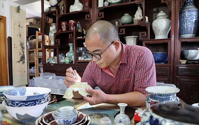 图示：近十年来，罗国新一直收集、研究历朝历代的陶瓷残片，几近痴迷。因高度近视，罗国新常年戴着一副眼镜，朋友都叫他“罗瞎子”。