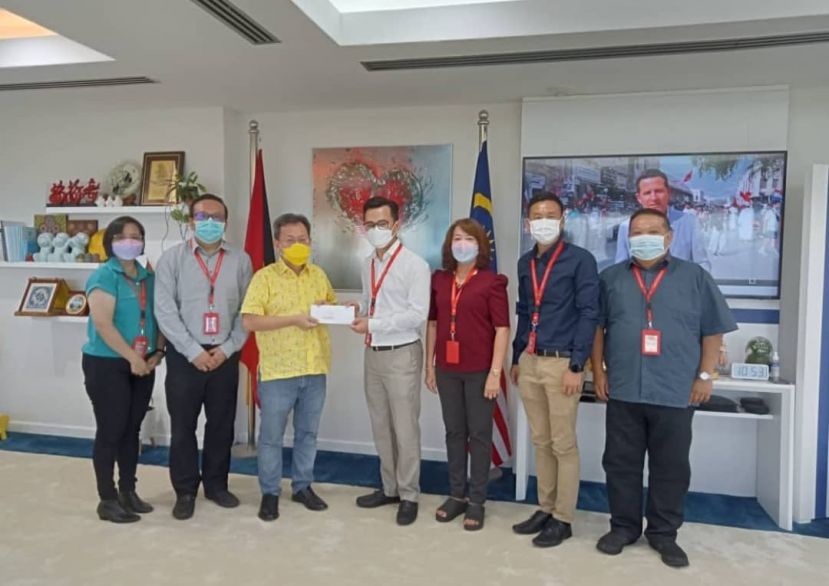  筹委会主席邢伟祥（中）在该会理事见证下，移交邀请函于砂州副总理拿督斯里沈桂贤医生。