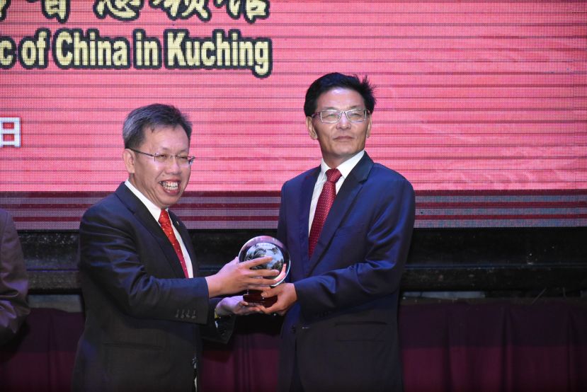 中国驻古晋总领事程广中(右)赠送纪念品给砂州首席部长，由砂地方政府与房屋部长拿督沈桂贤接领。