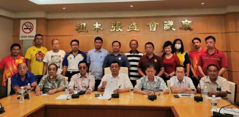 古晋福建公会会长拿督黄良杰（坐者左4）于紧急会议后与众人合影。