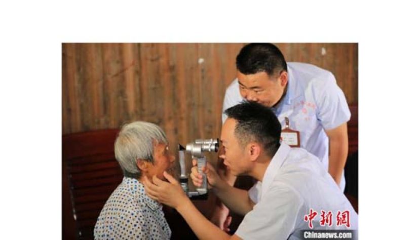 马应用手持裂隙灯显微镜为老人筛查眼部疾病。