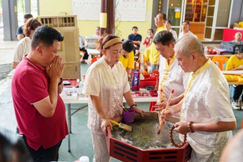 龙华神笔钟金瑞通过乩盘传达师尊圣谕，天猛公郭翼升合掌恭听。