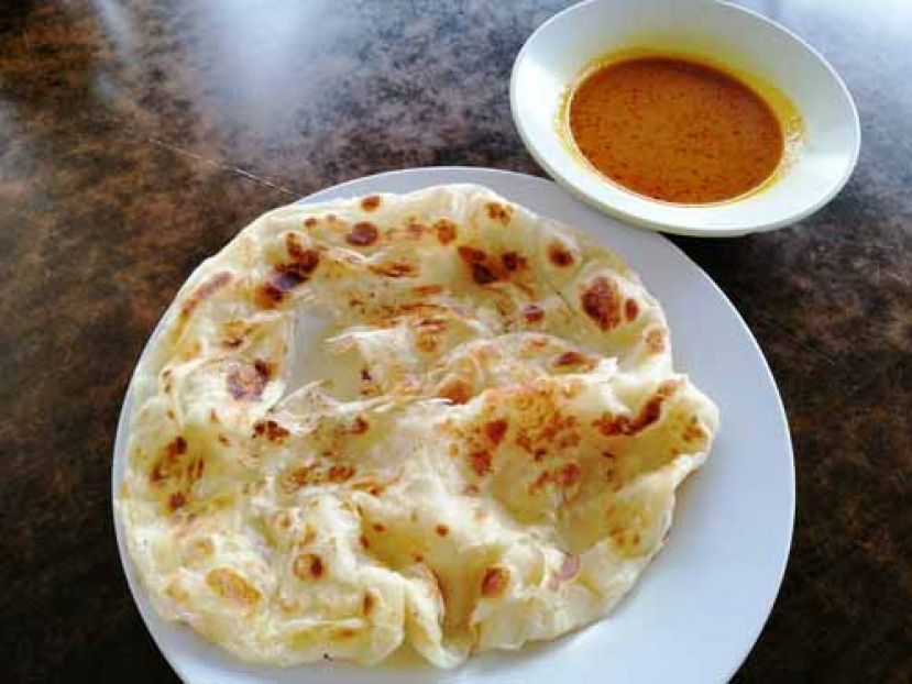 图示：食客会在享用印度飞饼时蘸着马铃薯加小扁豆咖喱酱汁享用。