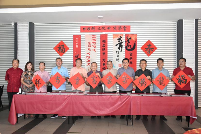 左起砂拉越文化研究学会理事甲必丹陈贻贤、活动筹委会主席张慧娇、晋汉连省张氏公会名誉会长张发真、晋汉连省华总副会长张光福、晋汉连省华总署理会长拿督王长福、砂拉越文化研究学会副会长孙春富、砂拉越文化研究学会会长拿督邓伦奇、斯木省华总会长拿督吴标生、古晋北市行政委员薛华东、中中校董会副主席沈楚鹏、砂拉越文化研究学会秘书长王运才展示挥春的作品。