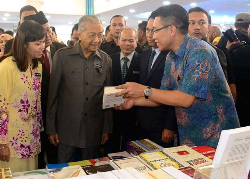 首相敦马哈迪（左2）在推介国家10年阅读计划活动后，巡视参展书摊。左为副教长张念群。