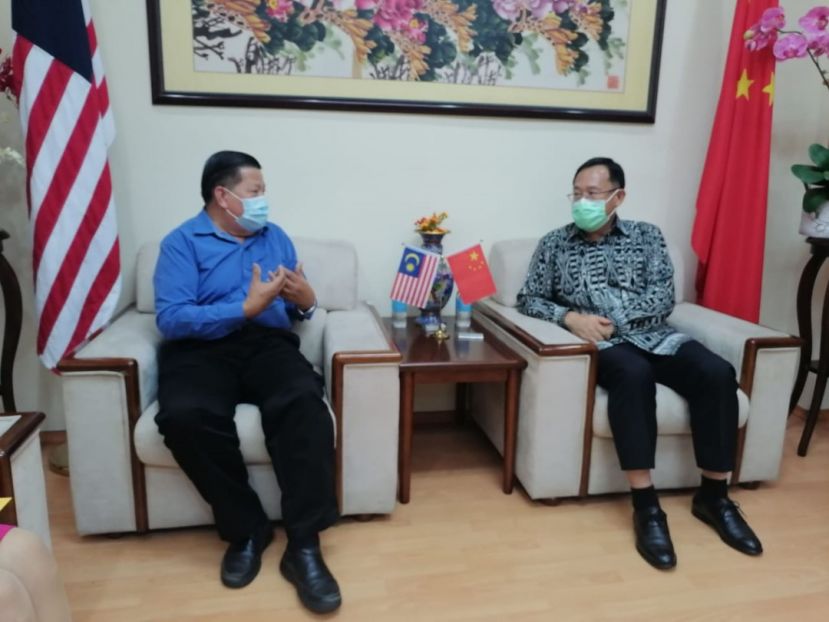 邢伟平总领事（右）与礼貌拜会的砂医总会长江宗兴交流。