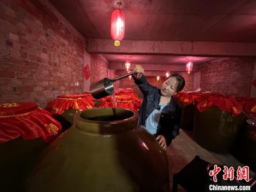 刘艳在自家&ldquo;庭院式&rdquo;生态酿酒作坊的酒窖里准备品酒。