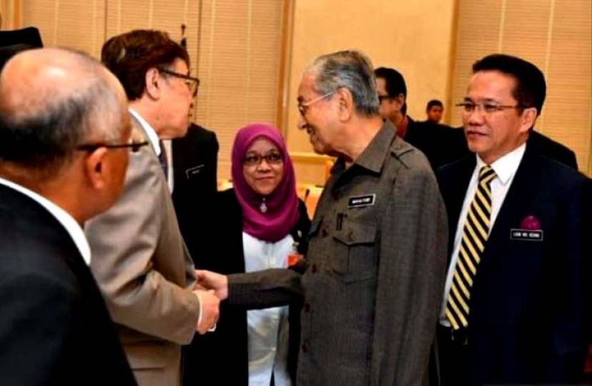 砂首长拿督巴丁宜阿邦佐哈里（左二）出席1963年大马建国契约指导委员会会议，与首相敦马哈迪（左三）握手寒暄。