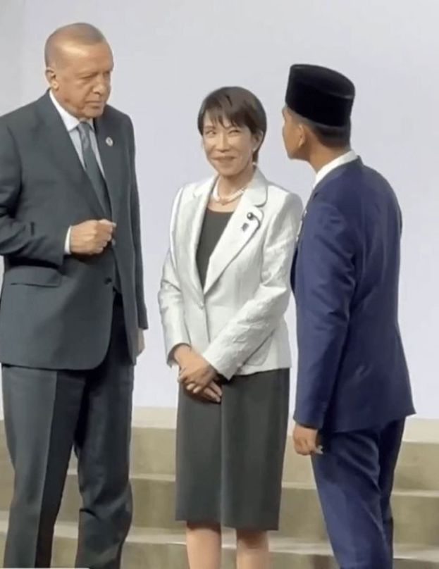 高市站在土耳其总统埃尔多安（左）与印尼副总统拉卡（右）之间，两人正隔着她交谈，身为&ldquo;夹心位&rdquo;的高市只能面露尴尬、陪笑硬撑。