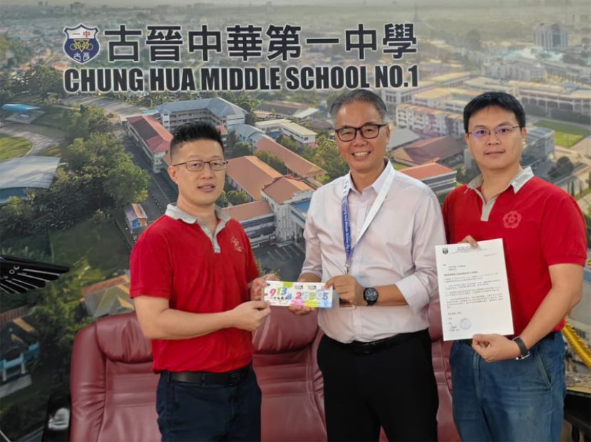 李志鹏校长（中）移交票券予一中校友会主席李嘉浩（左）。