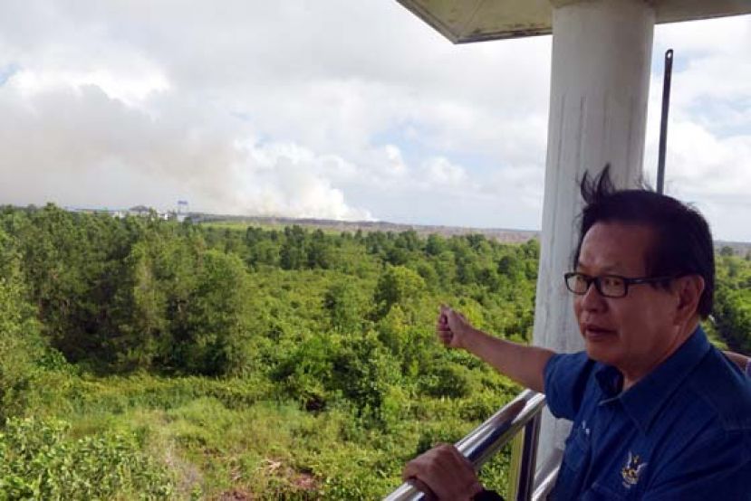 李景胜在野火监控塔上观察，上空尽是浓厚的烟雾。