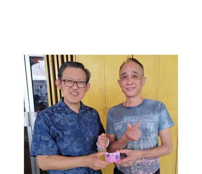 陈凯威（右）由薛华东手中接过所协助申请其老母亲特殊人士卡。