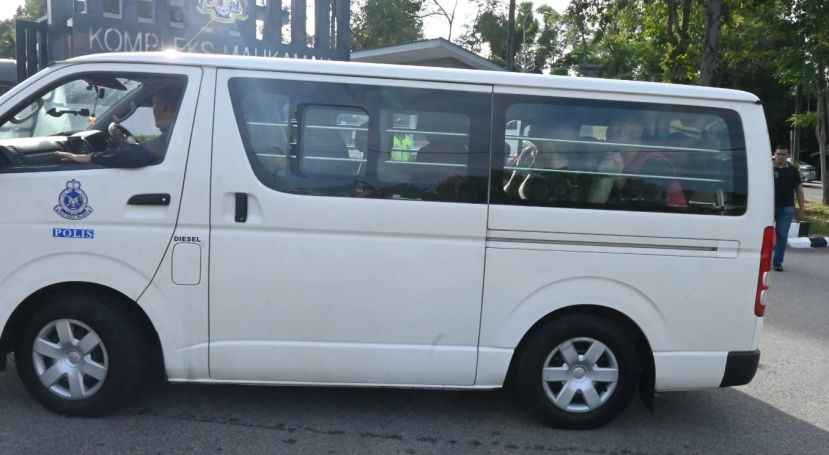 载着嫌犯的警方客货车抵达法庭时摄。