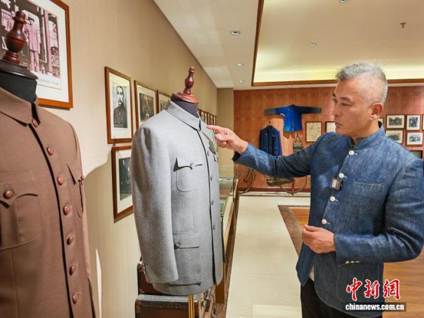 陈福星在工坊内向记者介绍中山装的文化含义。