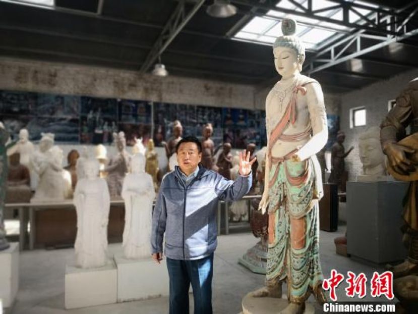 杜永卫介绍他彩塑的佛像。　