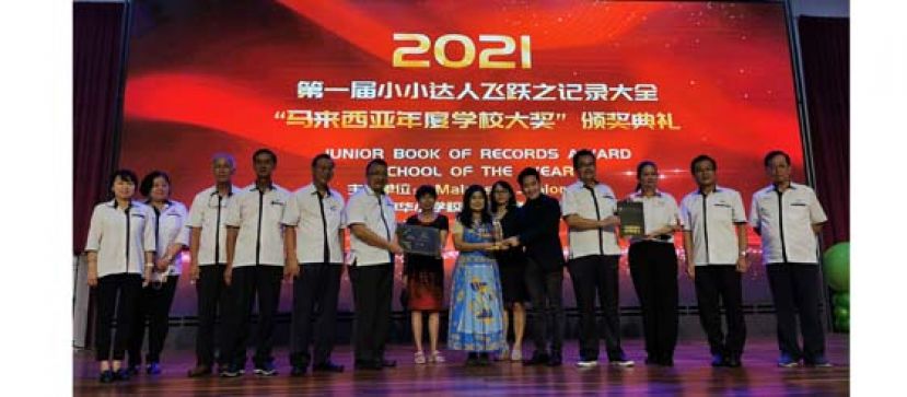 马来西亚少年协会代表林俊伟（右5）颁发奖杯予二小校长张丽萍，左起为古晋中华小学校董会副财政罗绍凤，二小视察郑姝萍，校董会副秘书长林光钟，二小监学唐才茗，副主席张光福，古晋中华小学校董会主席拿督蔡文铎，副校长黄广美，副校长陈燕丽，校董会秘书长田松茂，马来西亚少年协会代表林美云，校董会副财政周天龙及五小副主席黄云华。