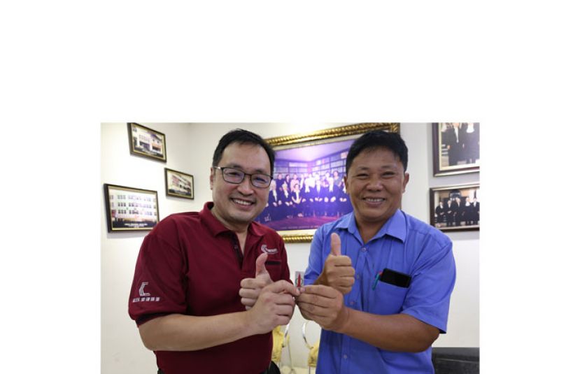 砂行动党主席兼国州议员张健仁（左）在其律师事务所喜遇火箭第二代忠实支持者赖维业，两人展示1970年代发行的第一个火箭标志的徽牌，场面温馨及热血感人。