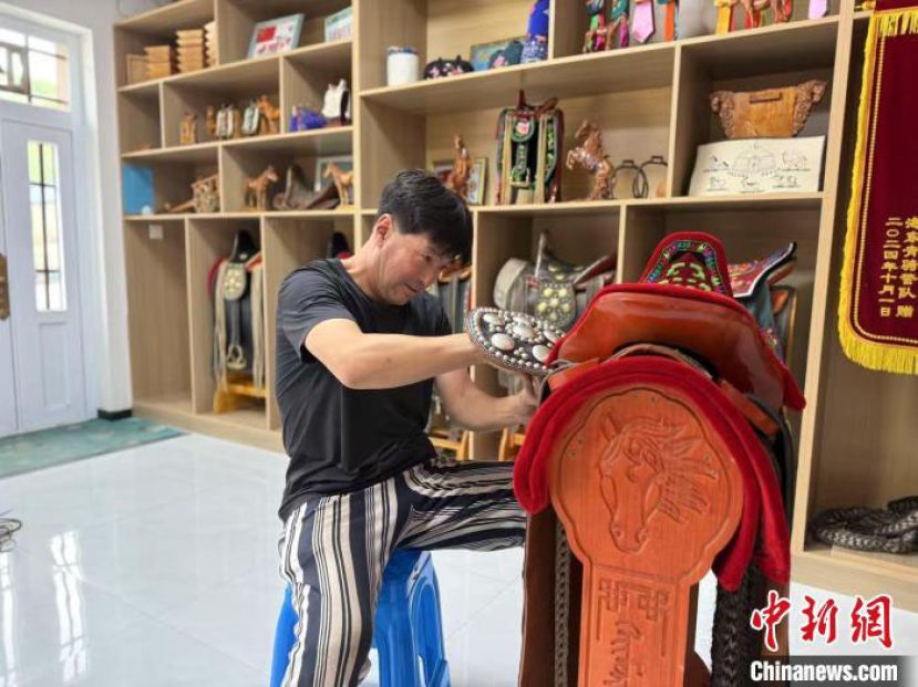 阿拉坦巴根正在调整刚做好的札萨克图传统马鞍。