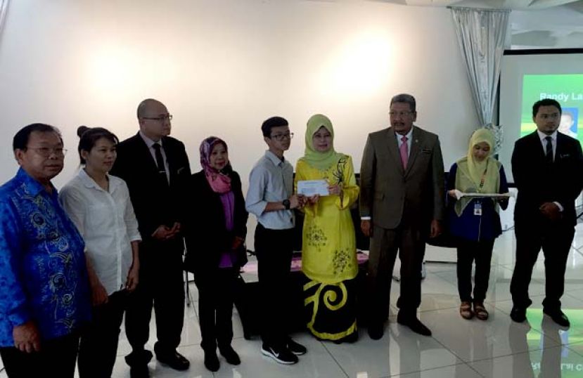 图：拿督斯里陈赛明（右四）颁发公民权批准证书予其中一位孩童，（右三）为内政部副秘书拿督旺达兰阿兹。