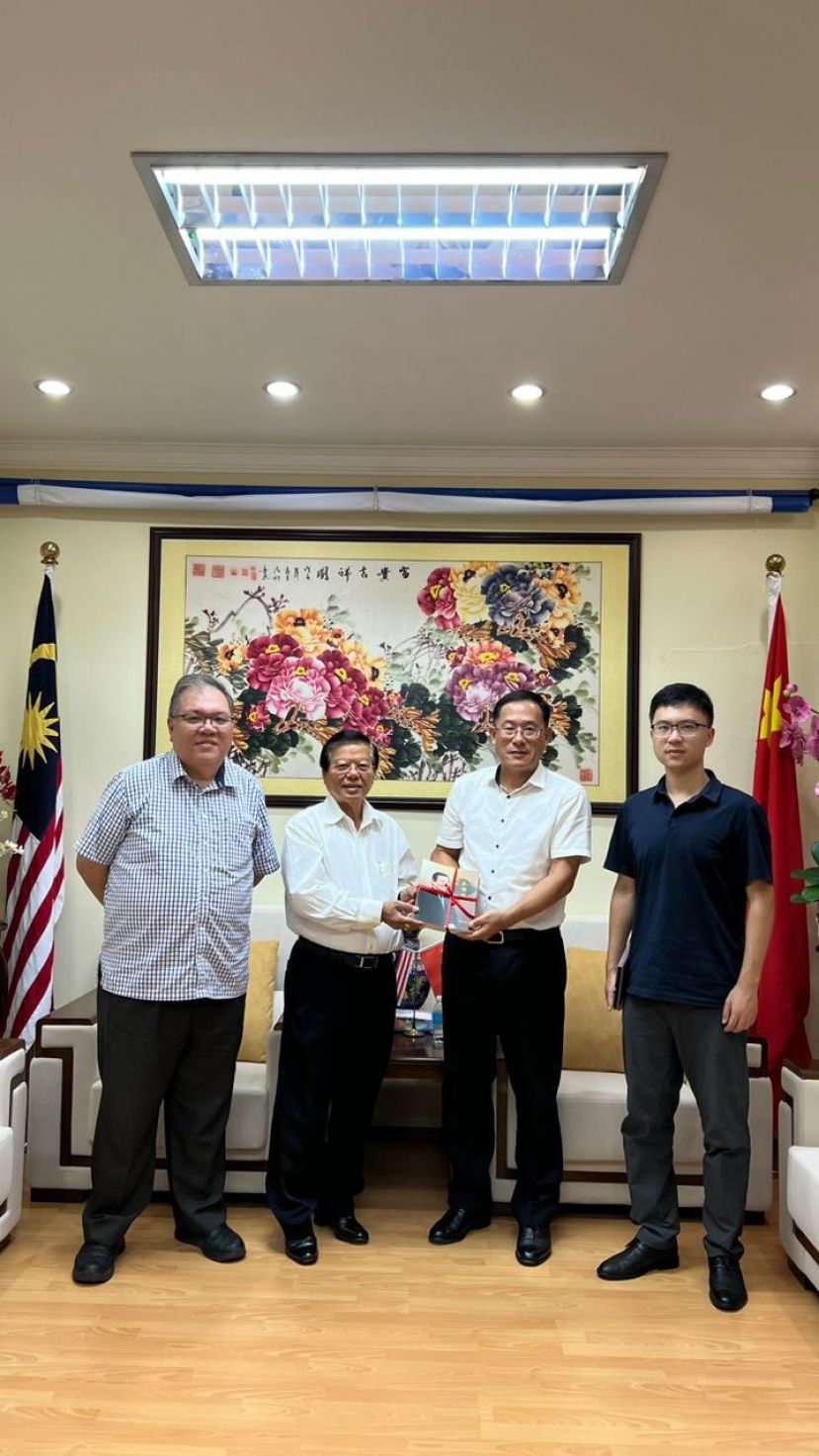 在拿督黄国辉（左一）的陪同下，拿督叶金来律师（左二）赠送著作《那些年永恒回忆》予中国驻古晋总领事邢伟平（右二）。