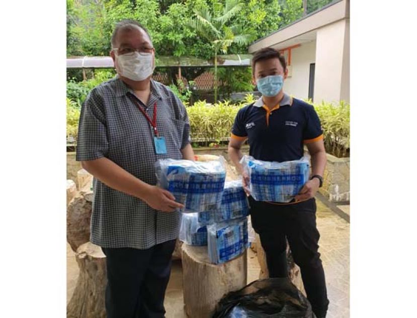 古晋中友会会长拿督黄国辉（左）移交3000个医用口罩予达迈国际青商会会长陈映佐（右）。