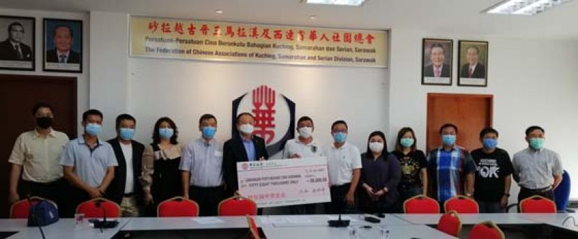 在砂拉越中资企业代表的见证下，中国银行东马区域总经理张宏坤（左六）移交58万令吉捐款予砂华总会长拿督黄良杰（右七），以支援前线医务人员。