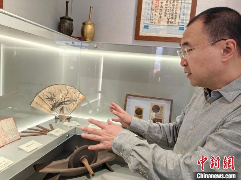 上海市中医文献馆馆长贾杨向记者介绍海派中医文博馆中的老物件。