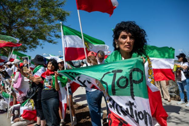 民众高举一面巨大的伊朗国旗，抗议国际足总禁止在世界杯球场内展示伊朗革命前国旗的规定。