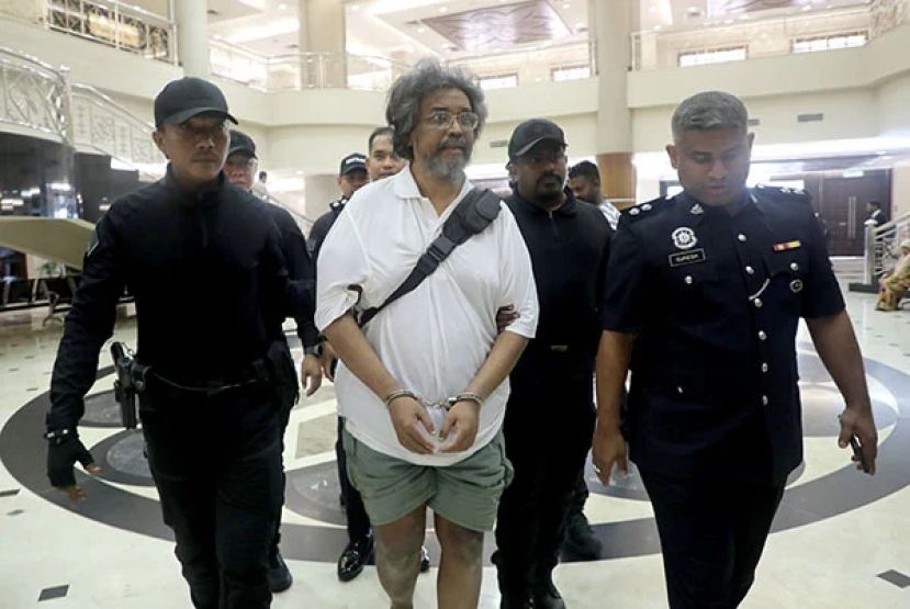 迪尼士纳拉亚兰奈尔（中）在隆市十五碑警区重案组（D9）警员押送下，抵达法庭大厦。