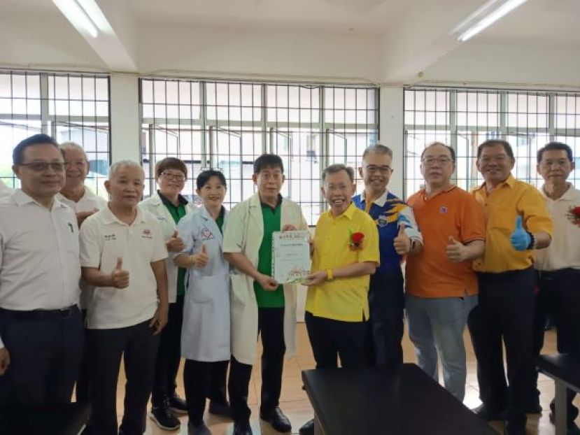  沈桂贤副总理（右4）颁发感谢状予安康国际中医负责人许国模。右2起为陈中兴医师、济兴善社总务林庆鸿、四中校长官晨阳及医师和校董们。