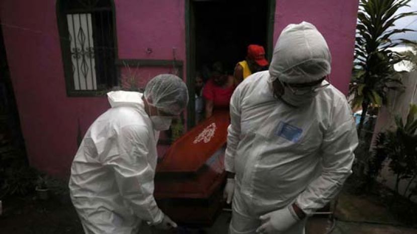 巴西单日暴增近2万7000例，再创新高。图为巴西工人正在搬运染疫死者的棺材。