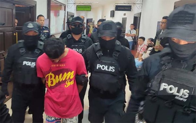 涉嫌虐杀女友3岁女儿的男子，被整装上阵的警员押往法庭时摄。