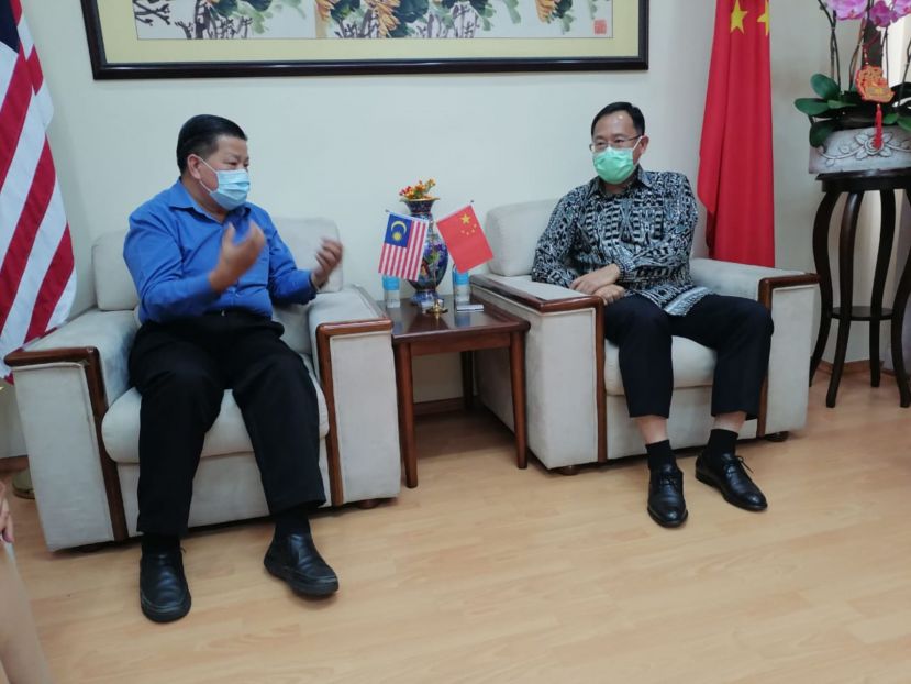 中国驻古晋总领事邢伟平（右）聆听砂医总会长兼亚洲中医技职学院院长江宗兴汇报推广砂中医技职教育事宜。