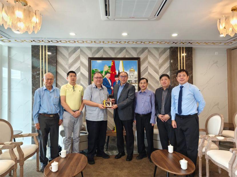 砂拉越中国友好协会常务副会长拿督黄国辉（左三）移交纪念品给汶莱中国友好协会会长陈家福博士（右四）、左一为砂拉越华文作家协会会长李福安、砂拉越中国友好协会 秘书长许瑞益。右一为汶莱中国友好协会秘书长柯长伟。