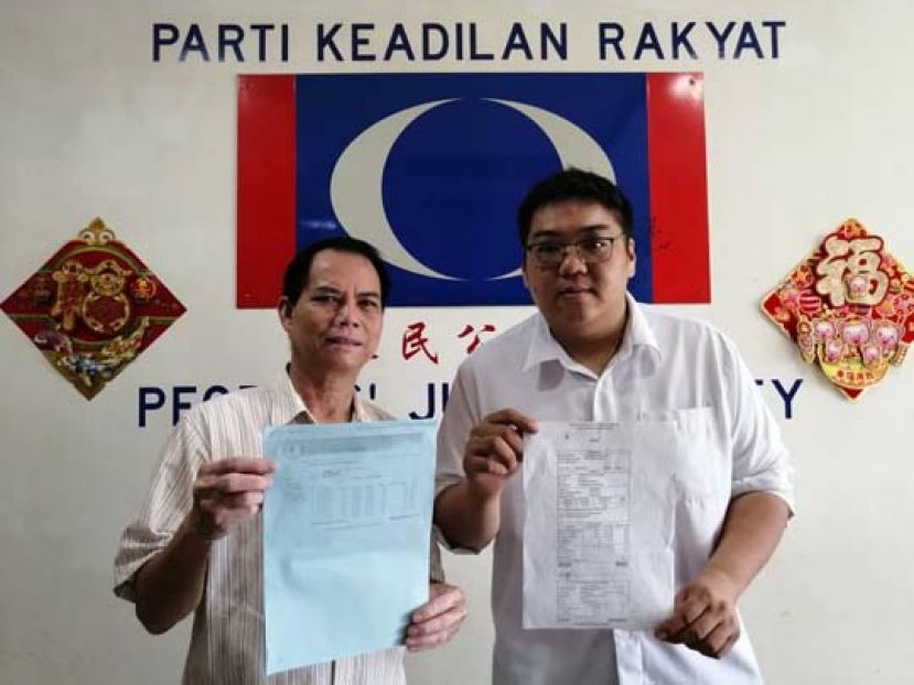 砂人民公正党西连区部署理主席雷吉纳阿贝勇（左）、砂人民公正党巴都林当区州立法议员施志豪律师特别助理兼砂人民公正党实旦宾区部青年团团长莫惠中律师（右），一同展示西连区居民长年无自来水可用，却在水费单上被指“积欠”大笔水费的水费单。